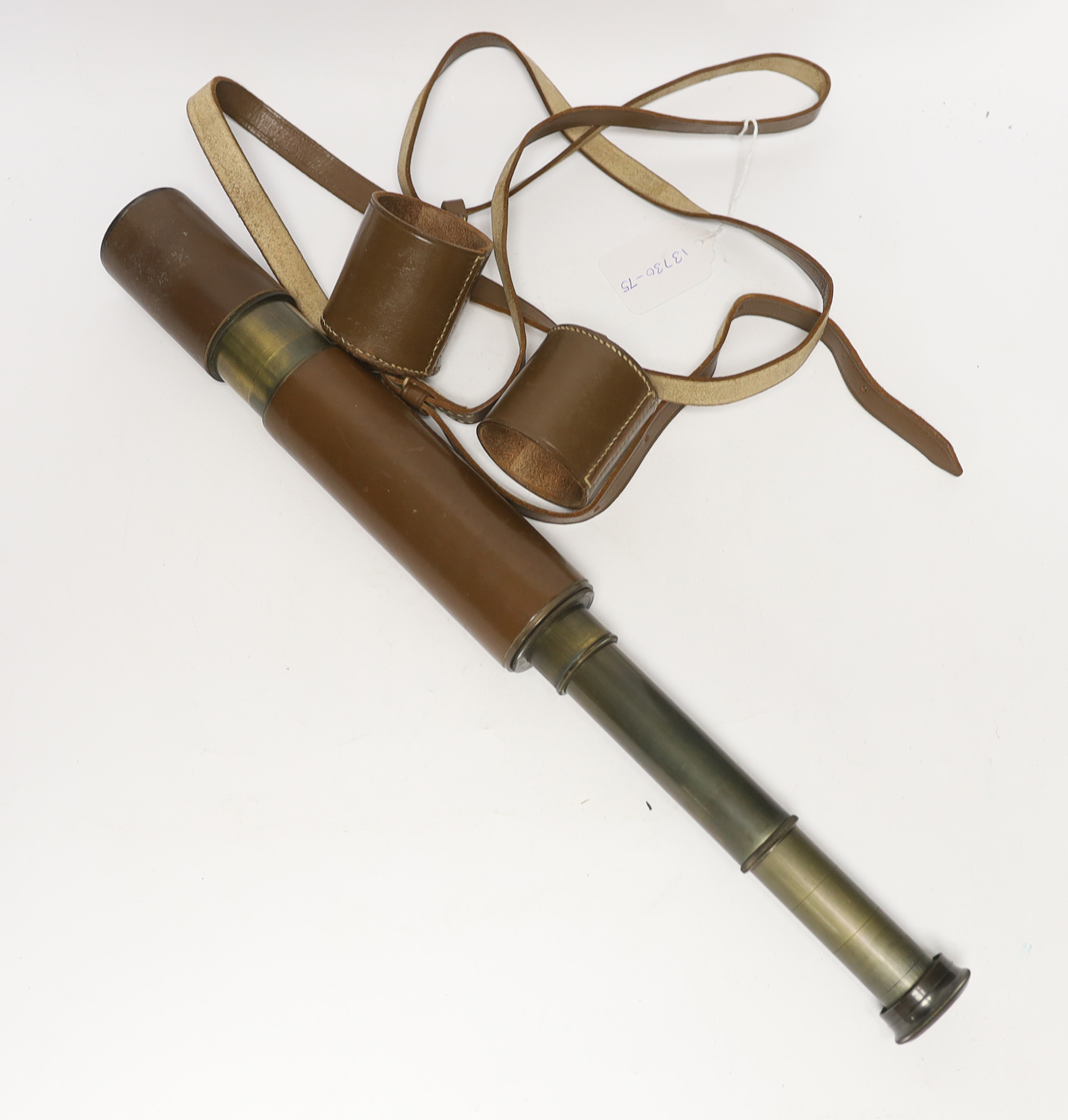 A leather cased three-drawer telescope with carrying strap, 27cm closed, 69cm fully opened